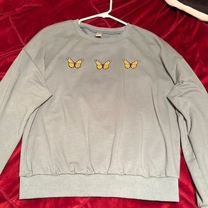 green crewneck with butterflies